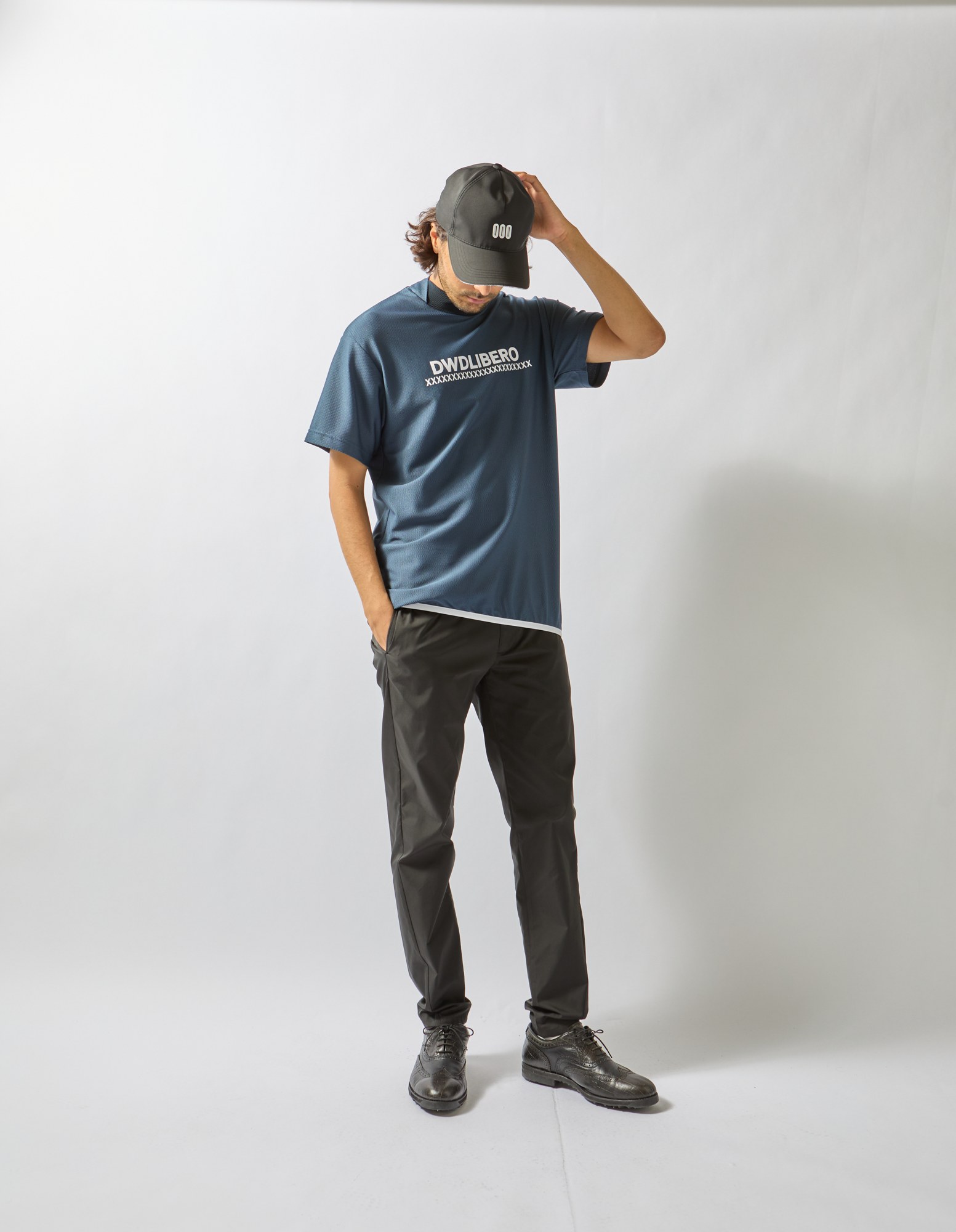 ネイビーのロゴトップスと黒のパンツ