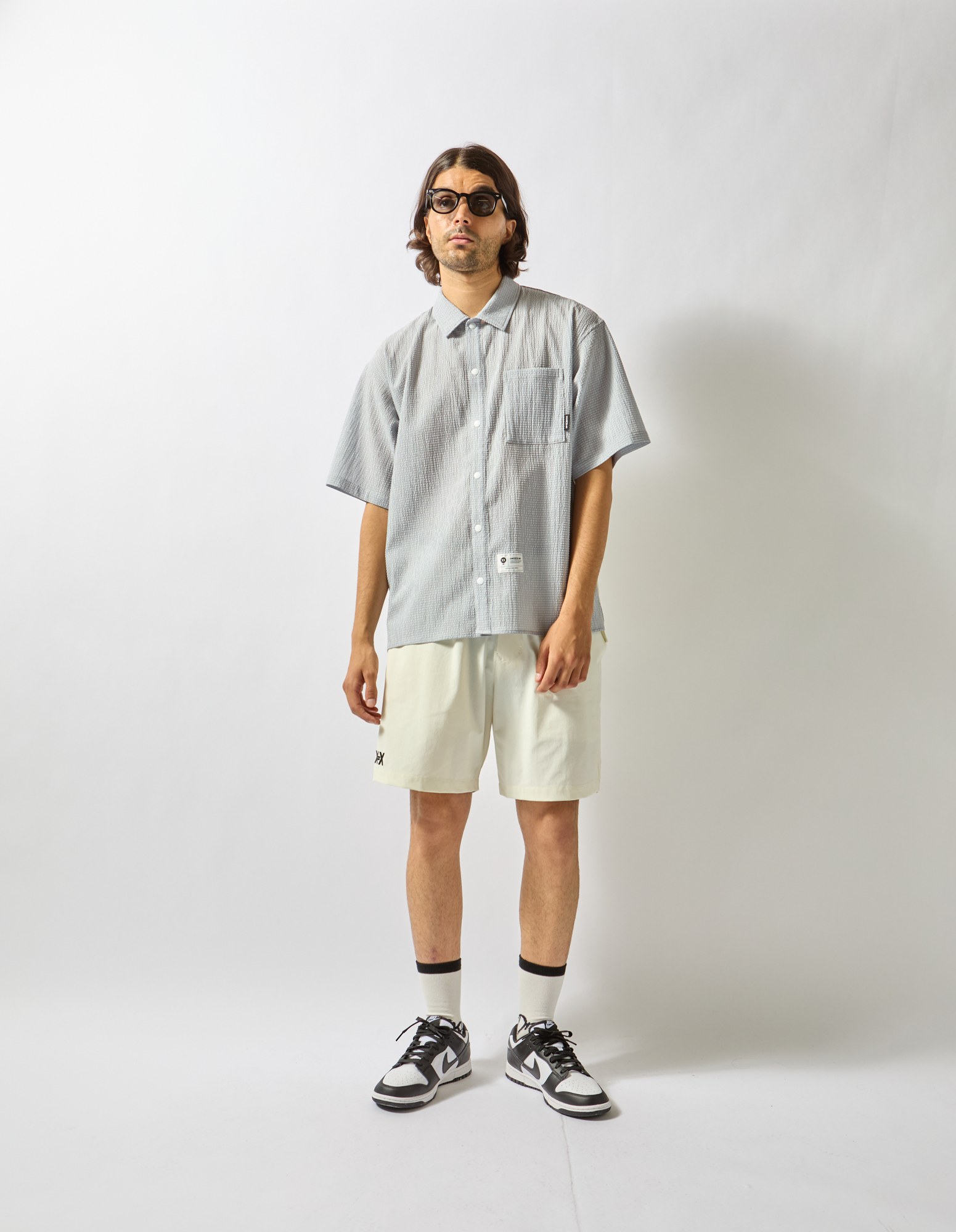 グレーの半袖シャツと白のショートパンツ